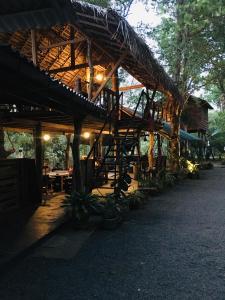 um edifício de madeira com uma mesa e cadeiras por baixo em Tree house Hostel Sigiriya em Sigiriya