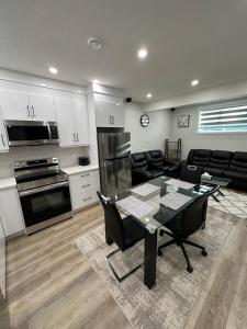 a kitchen and a living room with a table and chairs at 2 Bedroom 2 Washrooms Brand New Beautiful & Cozy Suite in Calgary