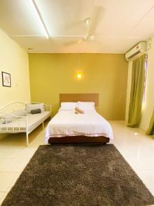 um quarto com uma cama branca e um tapete preto em Homestay Temerloh with private pool, Yhc Homestay em Temerloh