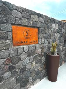 a sign on a stone wall with a potted plant at Thimari Lodge in Fira