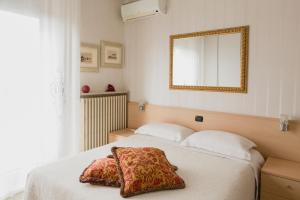 a bedroom with a bed with a mirror on the wall at B&B Nonna Gina in Bardolino