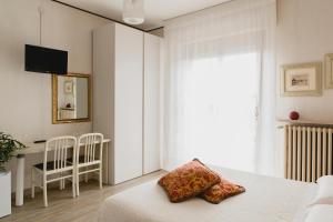 a bedroom with a bed and a table and a window at B&B Nonna Gina in Bardolino