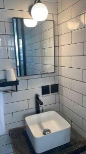 a bathroom with a sink and a mirror at The Drupadi Apartments Studio Gordy in Seminyak