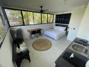 a bedroom with a bed and a kitchen with a sink at Studio Gordy in Seminyak