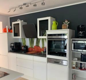 een keuken met witte kasten en een fornuis met oven bij Ferienwohnung Mühlenblick in Kempen