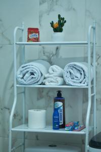 a towel shelf with towels and a bottle of soap at Lomes cozy home in Dar es Salaam