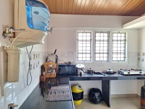 a kitchen with a counter and a stove and windows at Suvarna Grande Homes in Mangalore
