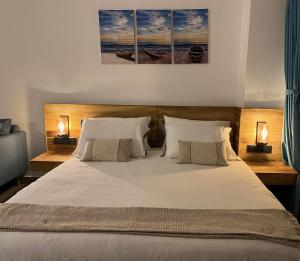 a bedroom with a large white bed with two lamps at Beachside Studio Retreat in Negombo