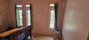a hallway with two windows and a wooden staircase at Dam Ri Private 2nd Floor - Near Airport & Batukaras in Tjidjulang