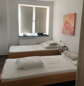 2 Betten in einem Zimmer mit Fenster in der Unterkunft Ferienwohnung Mühlenblick in Kempen