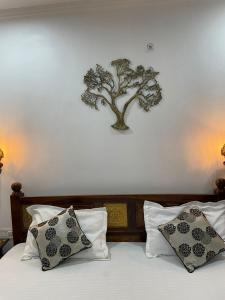 een boom aan de muur boven een bed met kussens bij Mrig Valley Resort, Homestay & Banquet in Kandikhal