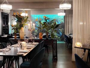 une salle à manger avec des tables et des chaises et un tableau de poisson dans l'établissement The Oriana Orange - Retro Hotel & Resort, à Orange