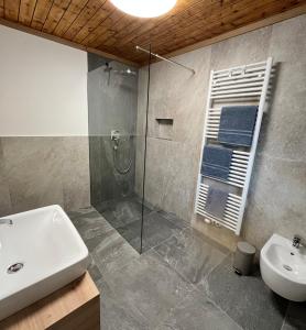 ein Bad mit einem Waschbecken, einer Dusche und einem Waschbecken in der Unterkunft Stroblhof in Sterzing