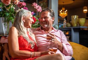 a man and a woman holding glasses of wine at The Oriana Orange - Retro Hotel & Resort in Orange
