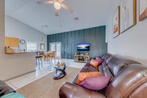 a living room with a leather couch and a kitchen at Cozy Autumn Creek Retreat in Orlando