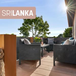 a patio with wicker chairs and a table at Sri Lanka in Steinberg