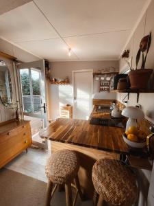 a kitchen with a wooden counter and two stools at The Secret Studio, Outdoor Bath & Pizza Oven in New Plymouth
