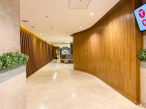 un couloir dans un hôpital avec un mur en bois dans l'établissement Shore2 Luxurious & Homely Suite near MOA, à Manille