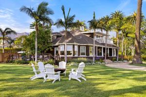 un grupo de sillas blancas y una mesa frente a una casa en Montecito Hamptons Style Gated Resort - Steps from the Beach, en Montecito