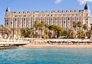 un gran edificio con una playa frente a él en 2 room CannesVacationRental by AmericanVacationLiving, en Cannes
