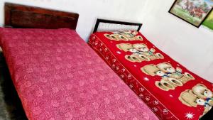 a bed with a red blanket with teddy bears on it at Samaraweera Family House in Kekanadura