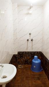 a bathroom with a white sink and a blue stool at HOTEL HELIX -- RAJPURA -- Budget Rooms for Family, Couples, Solo Travellers in Rājpura +50 photos