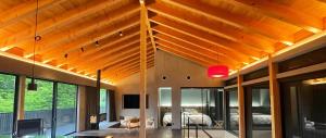 a living room with a wooden ceiling and a bedroom at MONS GORA Luxury Private Villa with Onsen Hakone Gora in Hakone