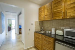 uma cozinha com um lavatório e um micro-ondas em The Oyster Bay Hotel Suites em Dar es Salaam