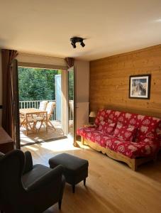uma sala de estar com uma cama vermelha e uma varanda em White Pearl em Chamonix-Mont-Blanc