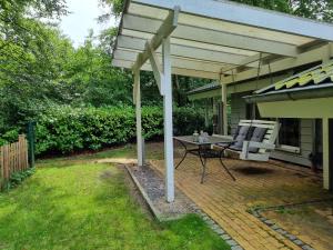 a patio with awning and a table and a chair at Ferienhaus Paulsen in Silberstedt