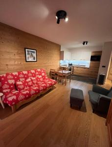 uma sala de estar com um sofá vermelho e uma mesa em White Pearl em Chamonix-Mont-Blanc