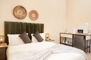 a bedroom with a white bed with a green headboard at Wish U Were Here in Cape Town