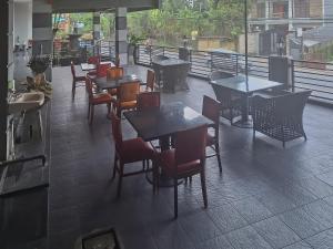 ein Restaurant mit Tischen und Stühlen auf einem Balkon in der Unterkunft RedDoorz @ Hotel Arwana Safari Puncak in Tagalbato