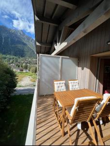 drewniany taras ze stołem i krzesłami na domu w obiekcie White Pearl w Chamonix-Mont-Blanc