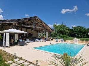 una piscina en un patio trasero con un pabellón en Maison Cassin47, en Lavergne