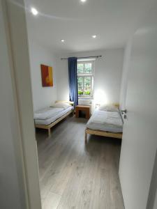 a room with two beds and a window at Gasthof Tatenhausen Ferienwohnungen in Tatenhausen