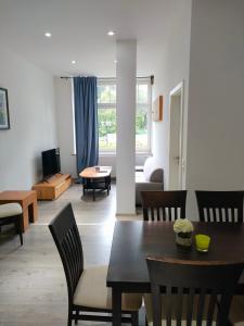 ein Wohnzimmer mit einem Tisch, Stühlen und einem Sofa in der Unterkunft Gasthof Tatenhausen Ferienwohnungen in Tatenhausen