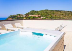 uma piscina no telhado de uma casa com cadeiras em Hotel Il Telamonio em Talamone