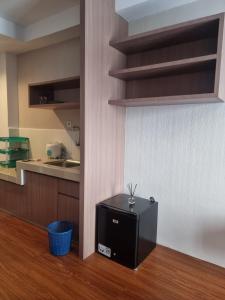 eine Küche mit einem kleinen schwarzen Kühlschrank in einem Zimmer in der Unterkunft skyview apartemen by gowsleep in Sunggal