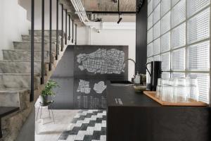 a kitchen with a black counter and a staircase at 軟寓 nńg inn in Tainan