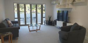 een woonkamer met 2 banken en een televisie bij Apartment Twelve in Taupo