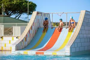 a group of people sitting on a slide in the water at Gitavillage California in Montalto di Castro