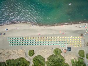 an overhead view of a beach with a group of umbrellas at Gitavillage California in Montalto di Castro