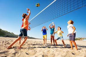 a group of people playing volleyball on the beach at Gitavillage California in Montalto di Castro