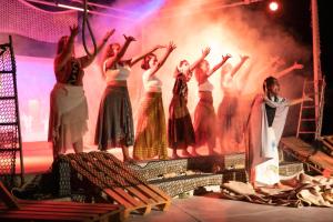 a group of women on a stage with their arms in the air at Gitavillage California in Montalto di Castro
