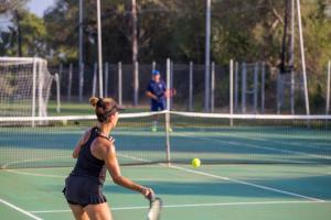 a woman swinging a tennis racket on a tennis court at Gitavillage California in Montalto di Castro