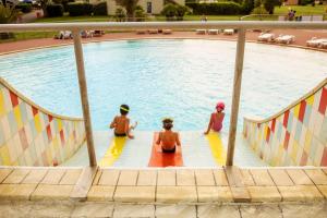 a group of people sitting in a swimming pool at Gitavillage California in Montalto di Castro