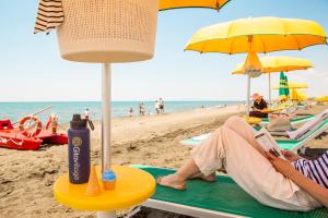 a person sitting on the beach reading a book at Gitavillage California in Montalto di Castro