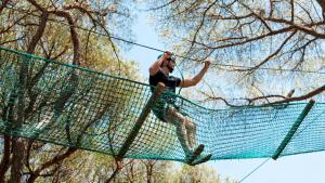 Un uomo su una teleferica su una rete di Gitavillage Le Marze a Marina di Grosseto