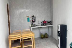 una pequeña cocina con mesa y nevera en Maisaba Coliving Cempaka en Dalung